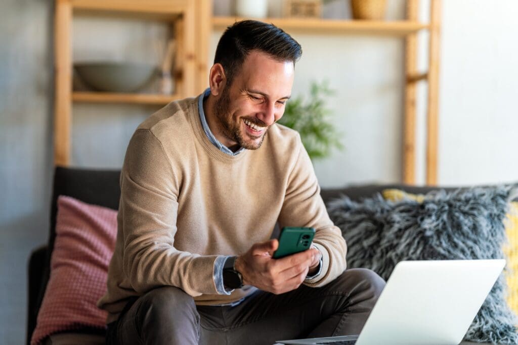 Portrait of a man using smart phone at home office. Work, freelance, social media technology concept