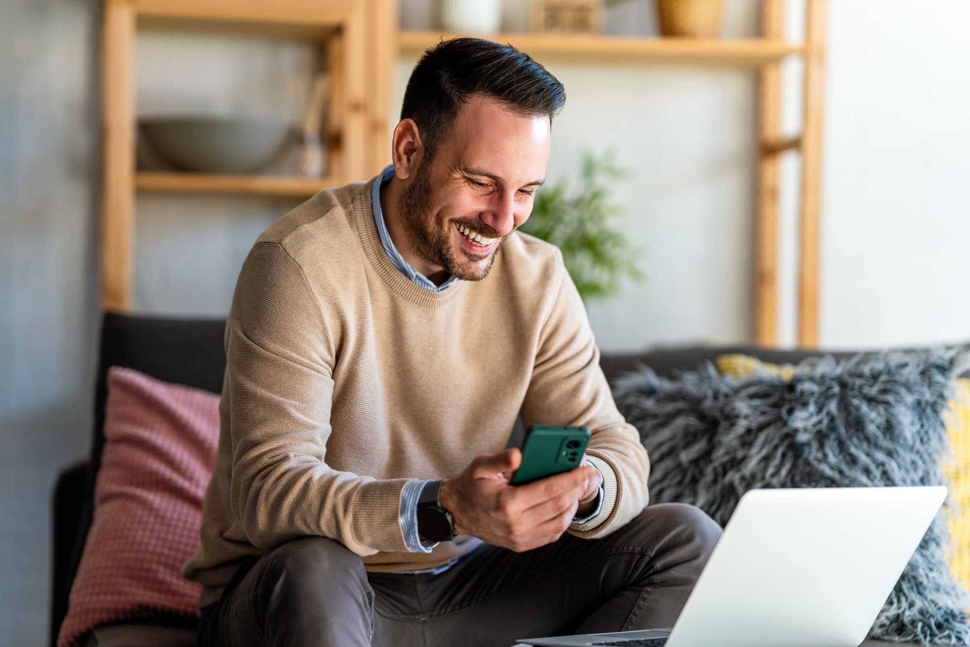 Portrait of a man using smart phone at home office. Work, freelance, social media technology concept