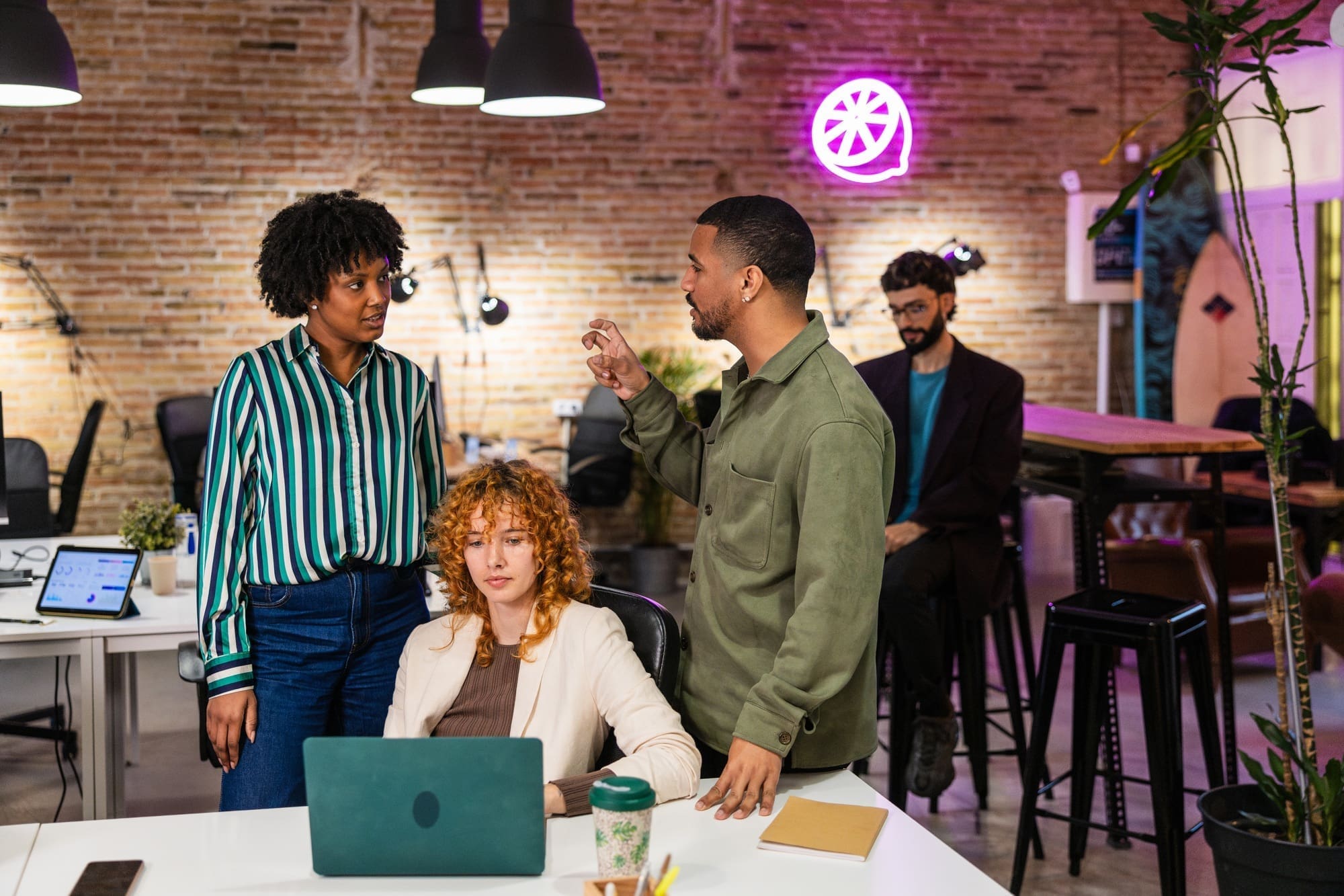 Marketing team discussing new project on laptop in modern office
