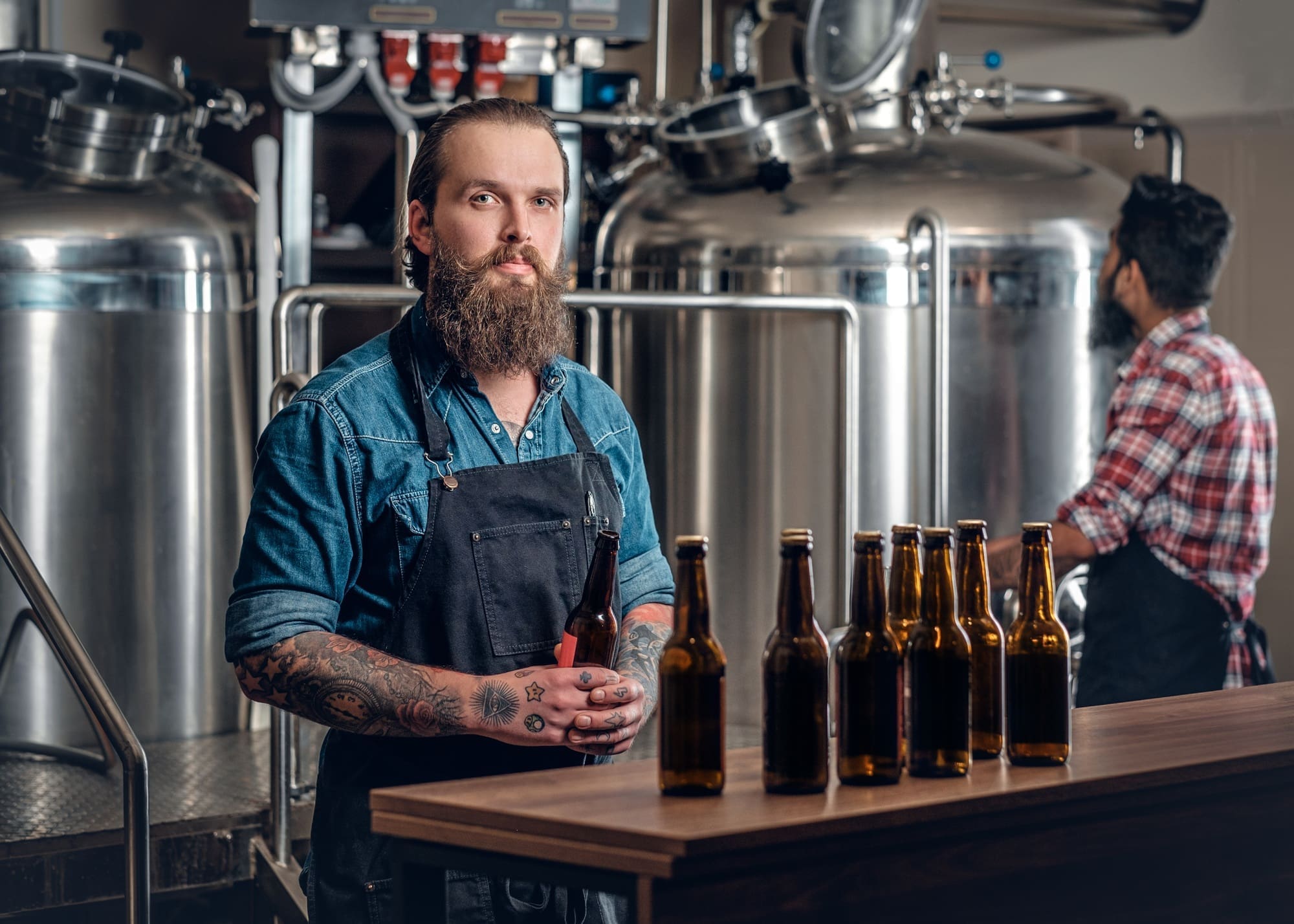 Two men presenting craft beer in the microbrewery.